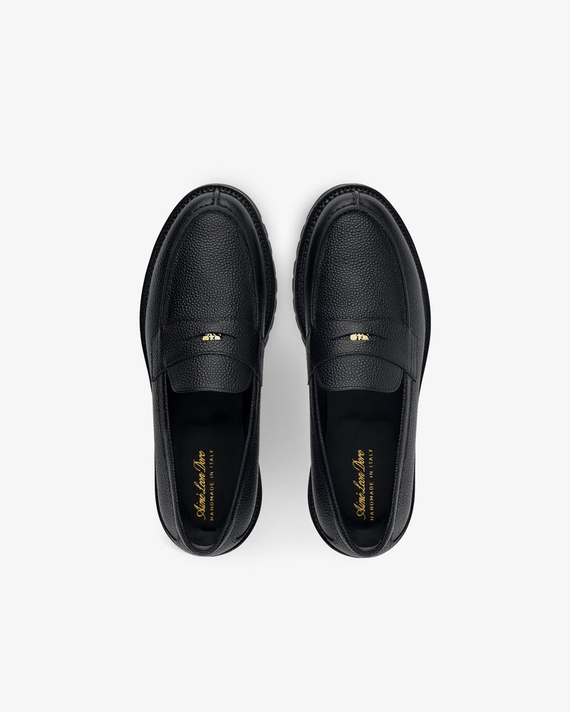 Lug Sole Queens Crest Loafers in black leather with textured finish, gold insole branding on a light background.