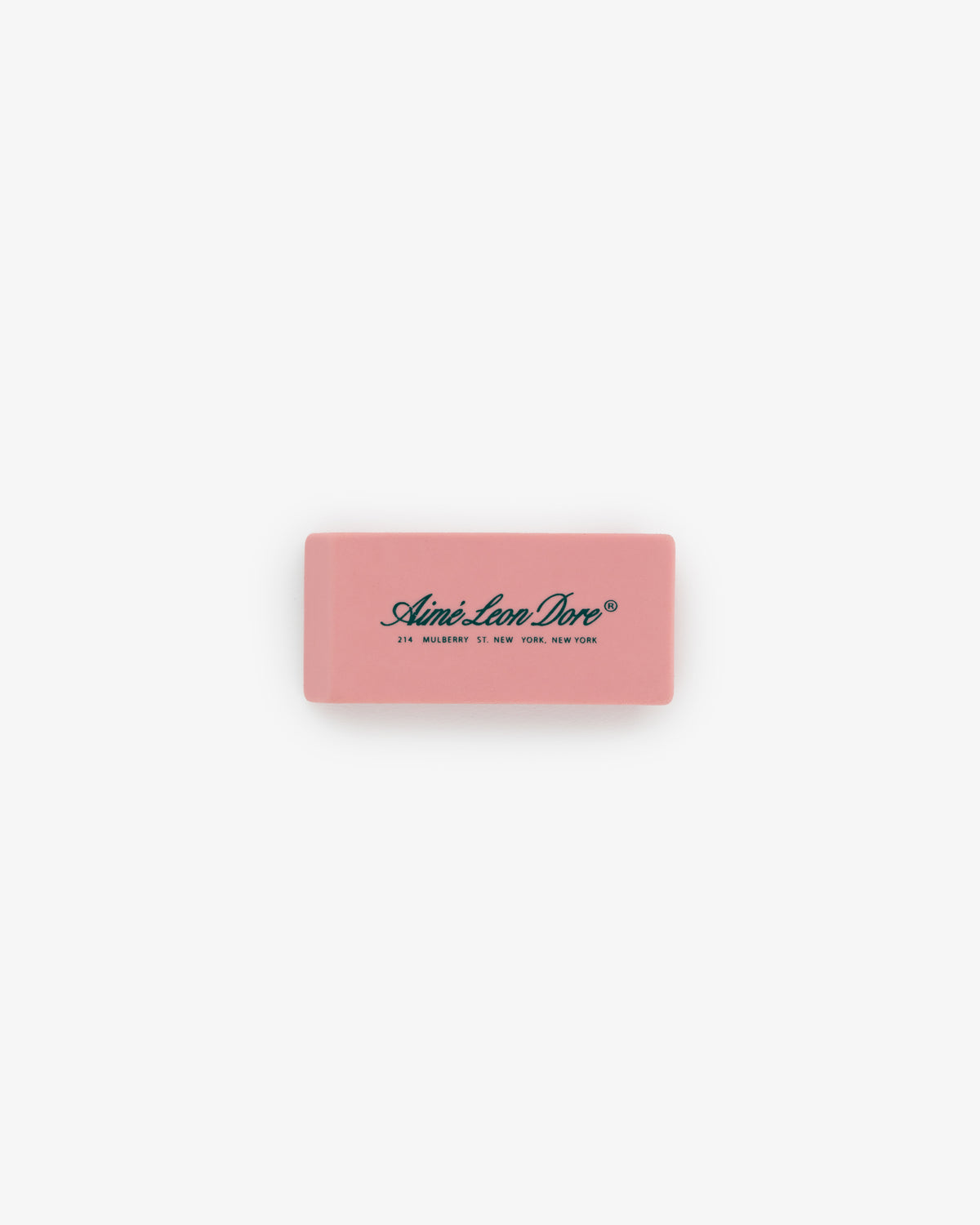 A pink rectangular eraser from the Eraser 3 Pack with Aimé Leon Dore and an address printed in black on top.