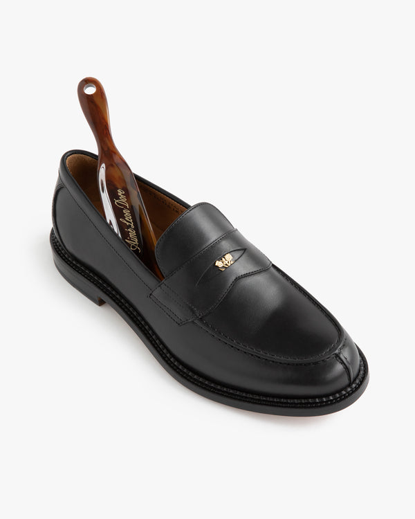 Queens Crest Loafer: black leather, small gold emblem, includes brown shoehorn.