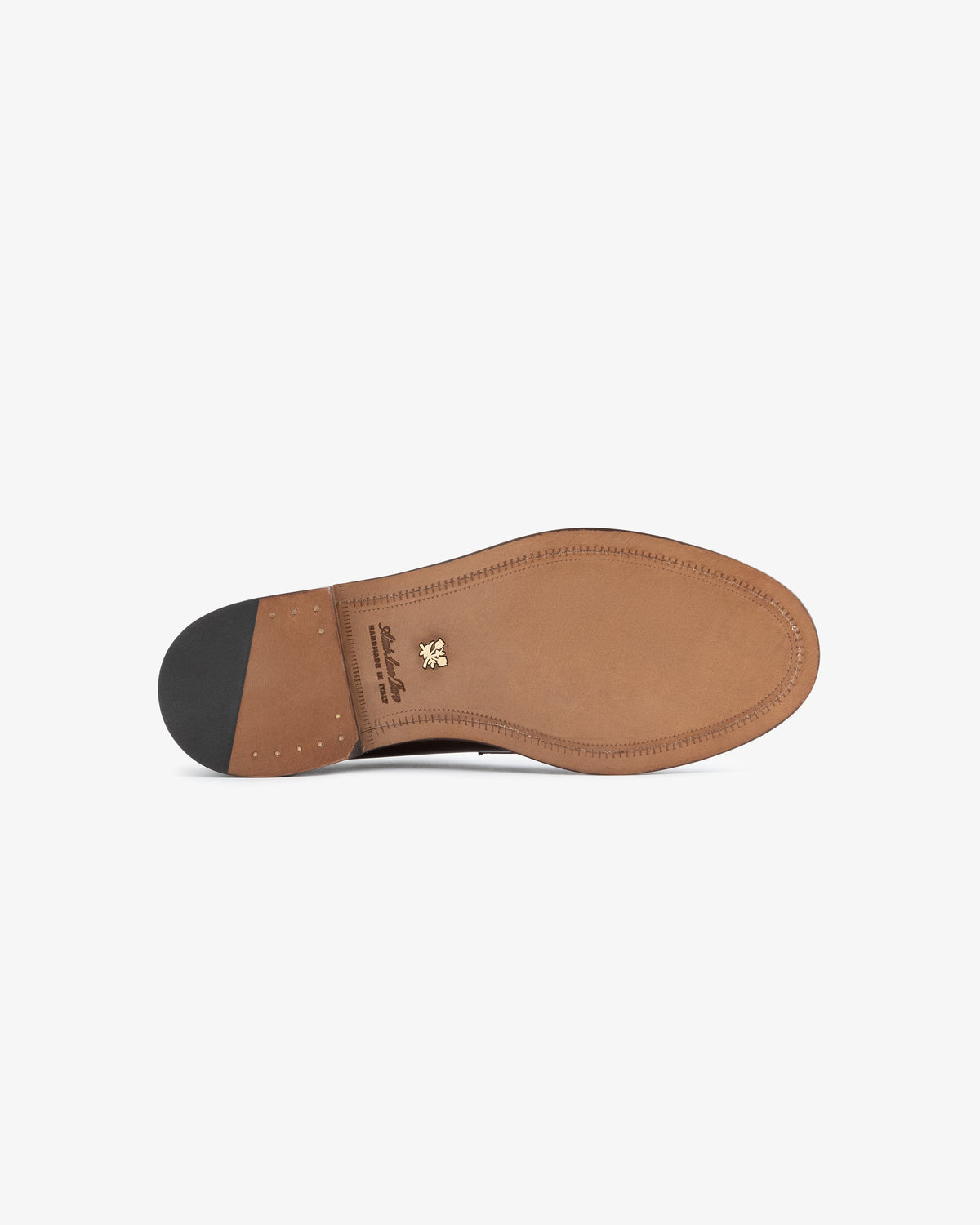 The image shows the tan leather sole with stitching and black heel of the Queens Crest Loafer.
