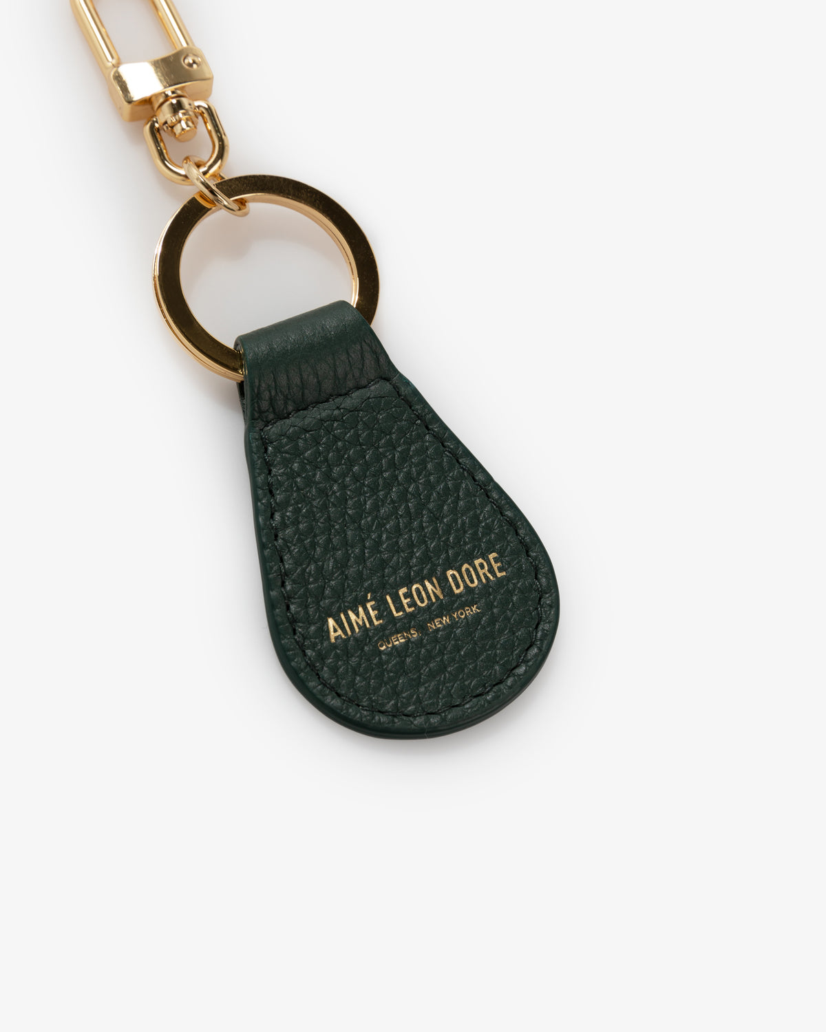 Leather Key Fob in dark green with gold hardware and AIMÉ LEON DORE text embossed in gold on the front.