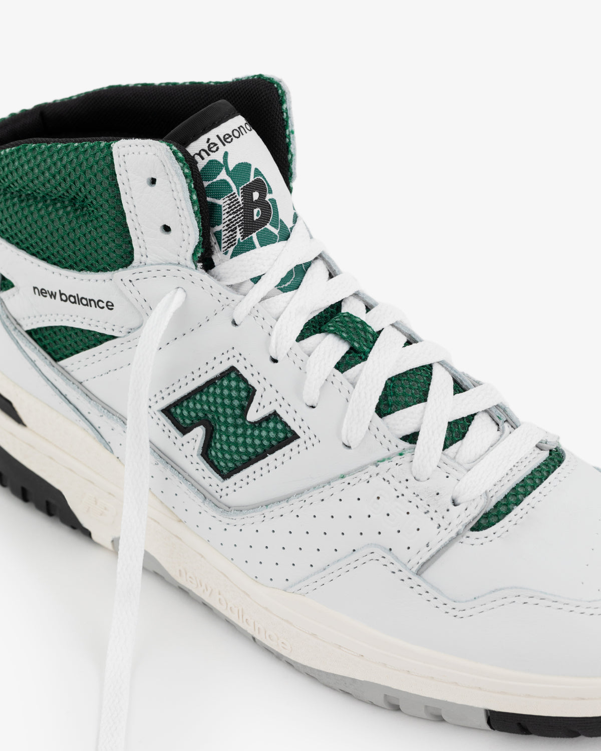 Close-up of a white and green ALD / New Balance 650R sneaker with perforations and visible branding on tongue and side.