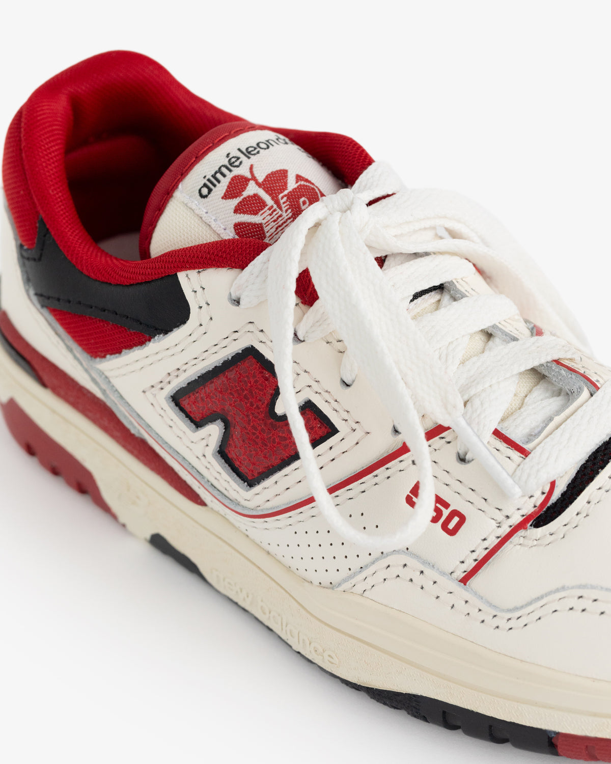 ALD / NB P550 Basketball Oxfords for little kids in off-white with red and black details, white laces, and branded tongue.