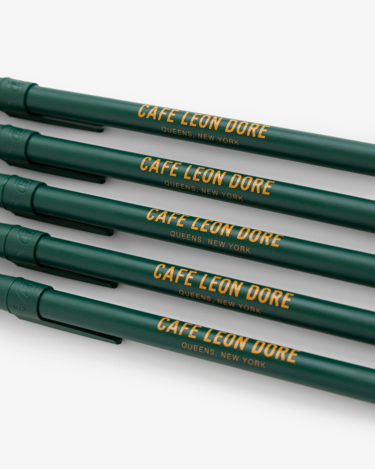 Pack of four green Café Leon Dore Ballpoint Pens with QUEENS, NEW YORK in yellow lettering on each pen.