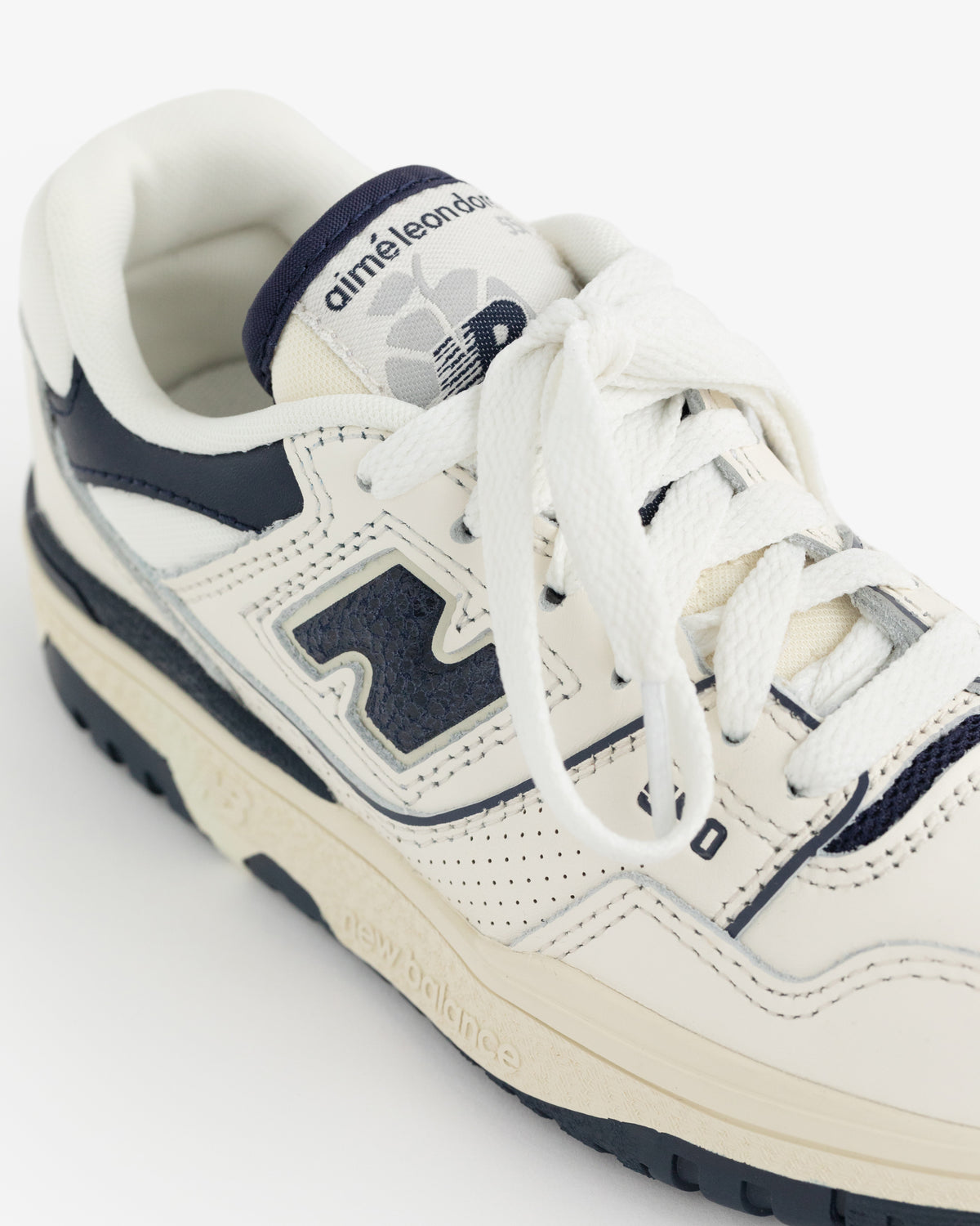 Off-white ALD / NB P550 Basketball Oxfords for little kids with navy accents and aimé leon dore tongue branding, top view.