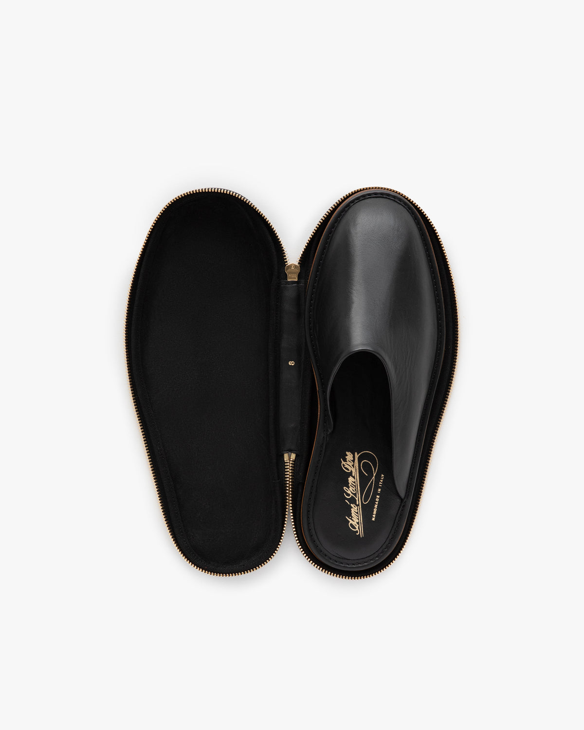 A Leather Travel Slipper in black, shown inside an open black zippered case, viewed from above.