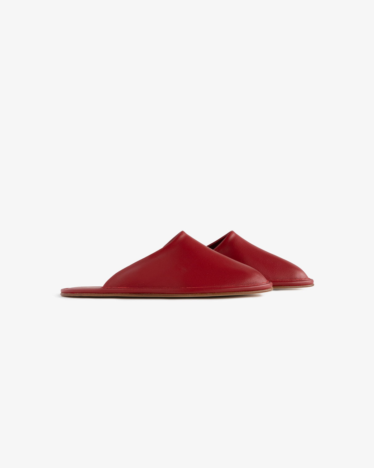 A pair of red Leather Travel Slippers with flat soles displayed on a white background.