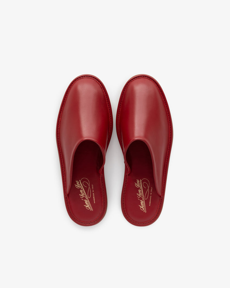 A pair of red Leather Travel Slippers with gold insole branding, seen from above on a white background.
