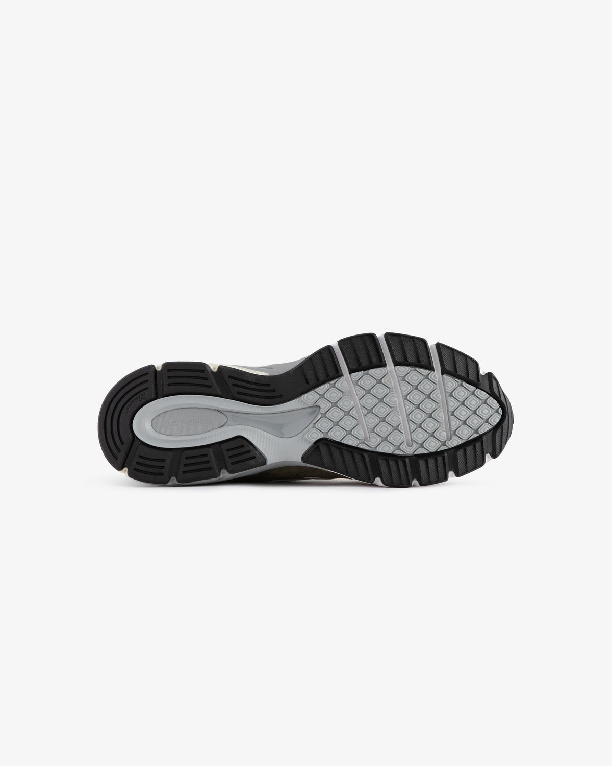The image shows the black and gray rubber sole of the ALD / New Balance 990v4 sneaker against a white background.