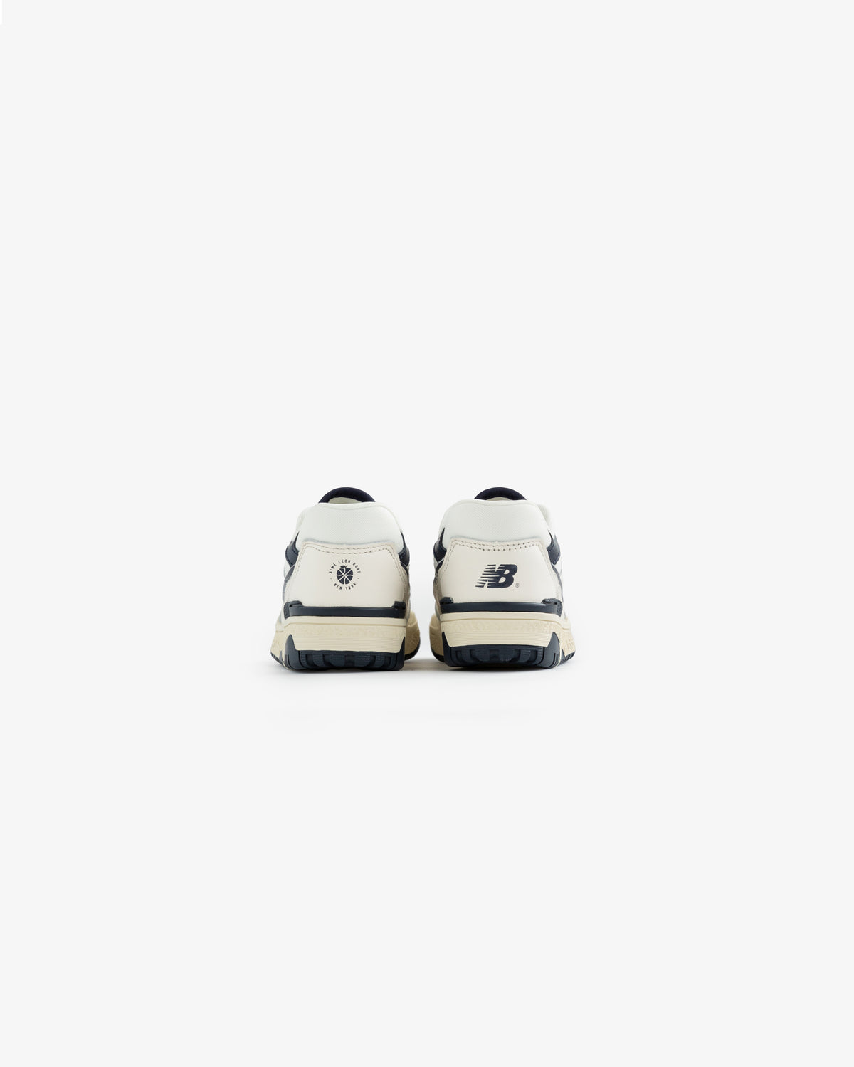 The ALD / NB P550 Basketball Oxfords for little kids in white and navy, shown from the back on a white background.