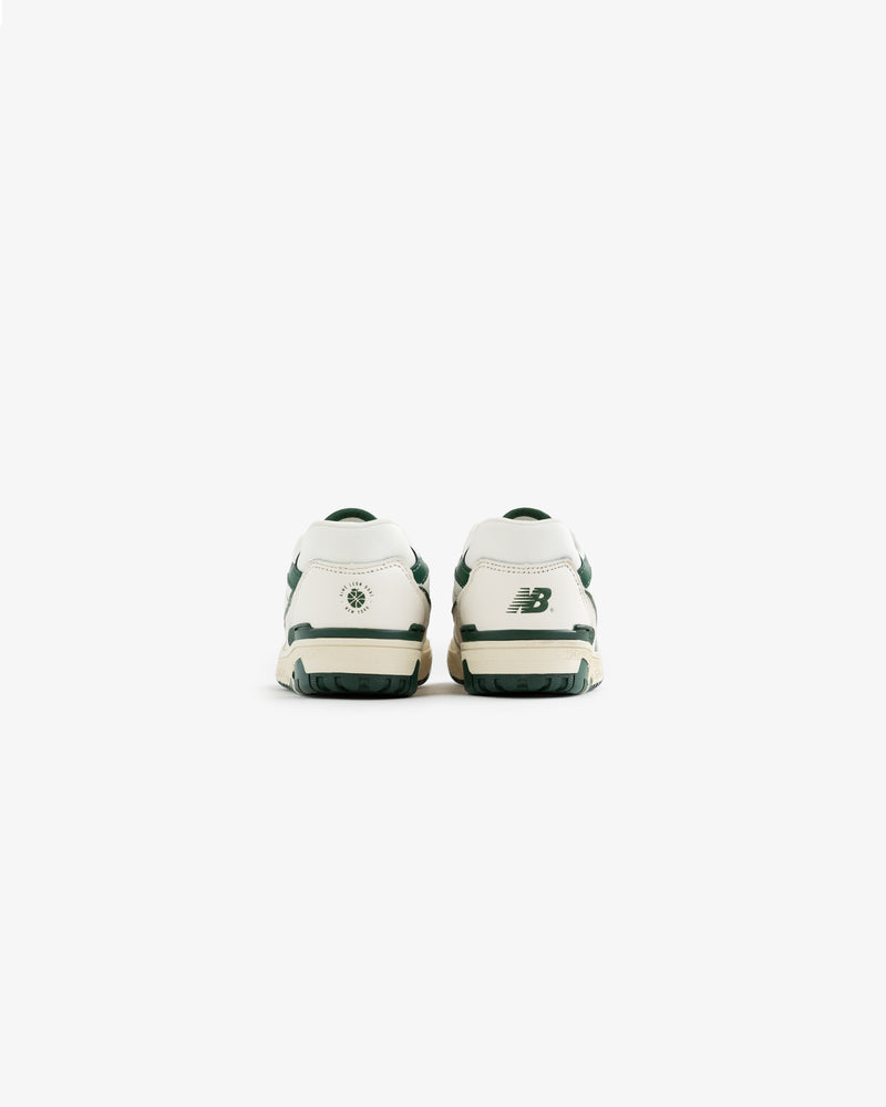 Back view of ALD / NB P550 Basketball Oxfords - Little Kids in white with green accents on a plain white background.
