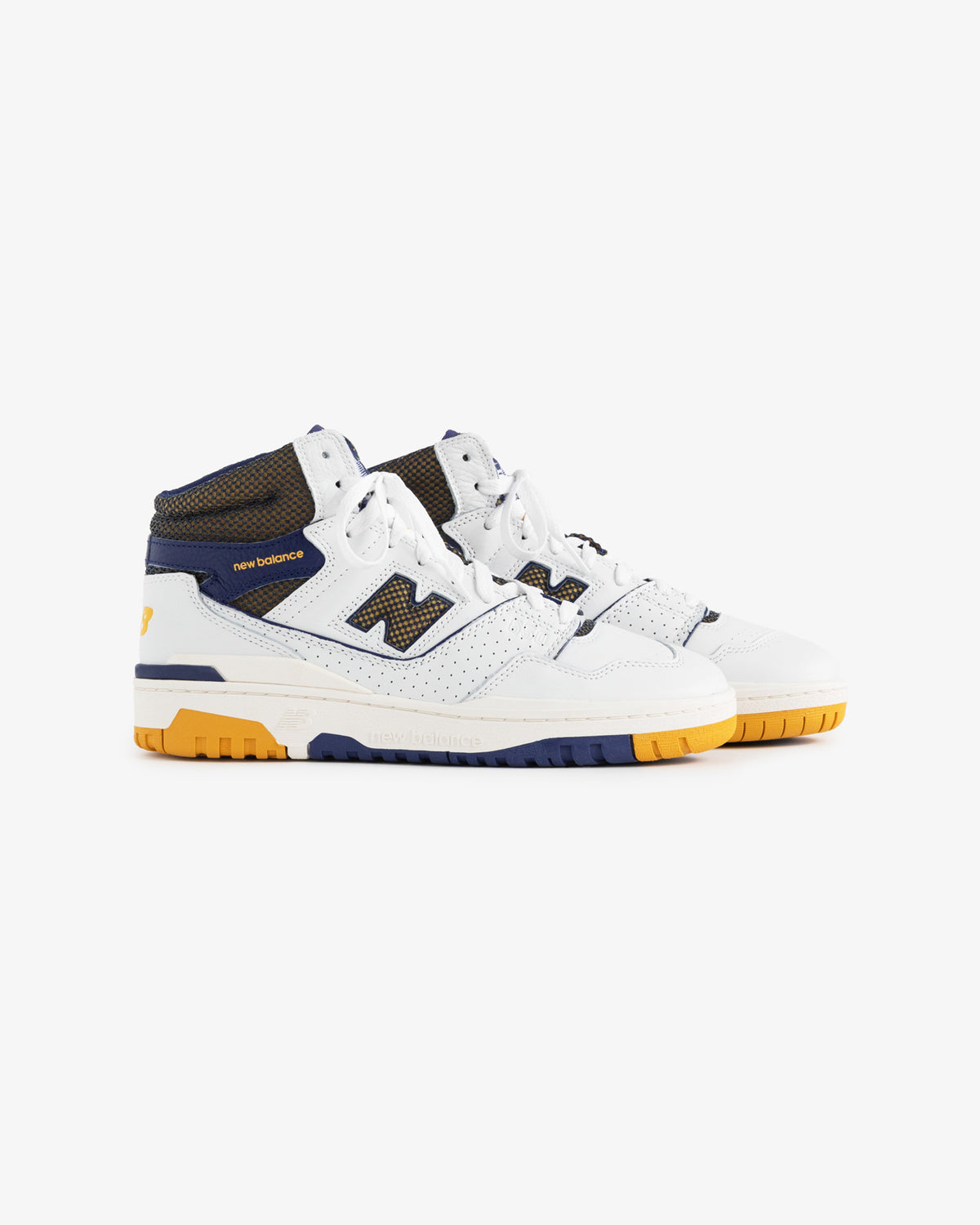 ALD / New Balance 650R sneakers in white and navy with yellow accents and perforated details on a white background.