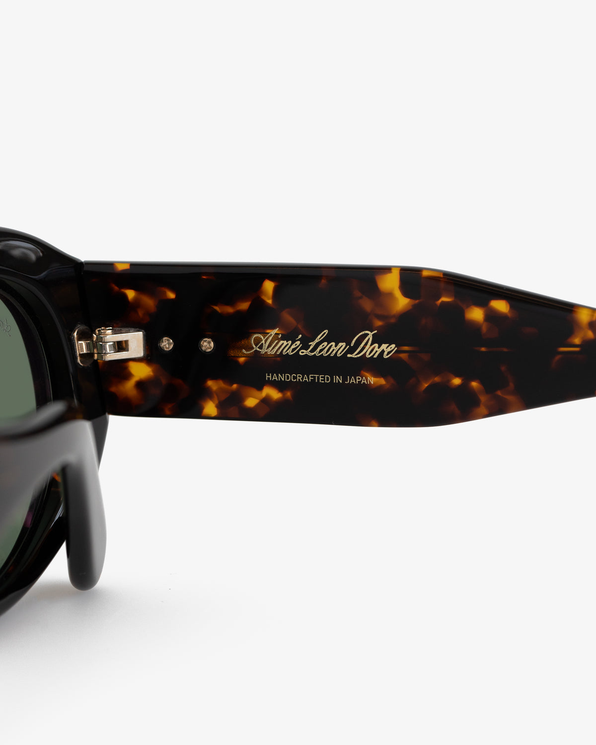 Close-up of Jackie O Sunglasses with Aimé Leon Dore HANDCRAFTED IN JAPAN in gold on the temple.