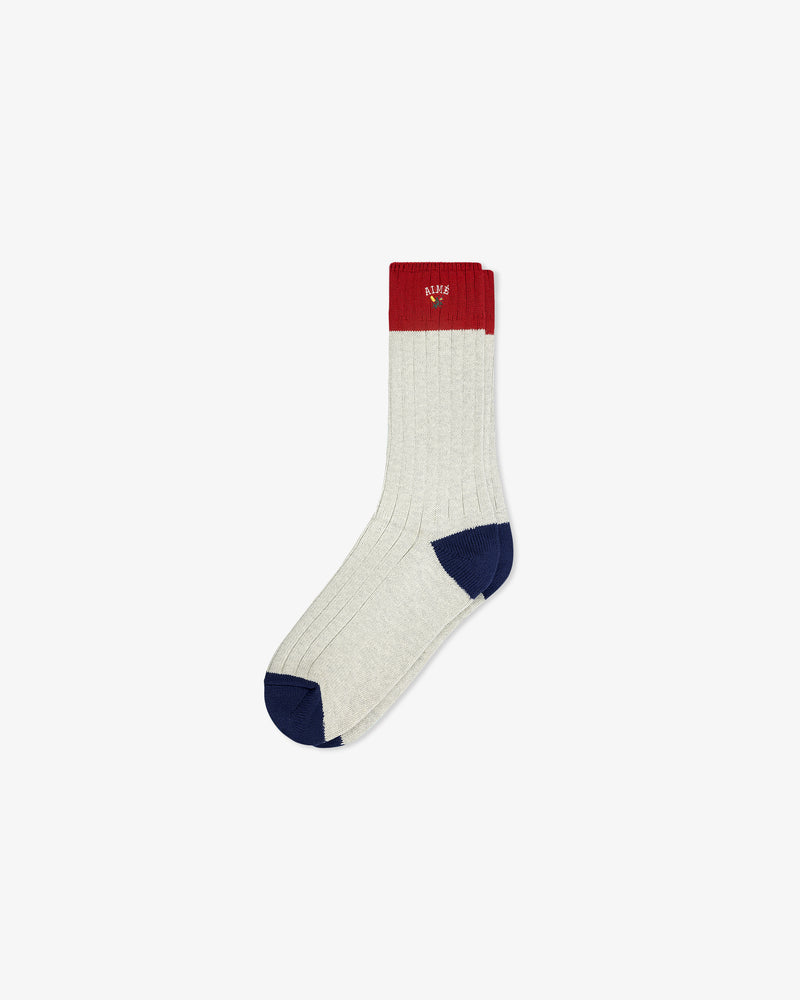Crest Varsity Sock: light gray ribbed sock with red cuff, navy toe, and navy heel on white background.
