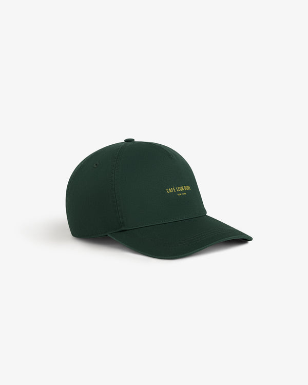 Café Leon Dore Logo Hat in dark green with yellow text, shown on a white background.