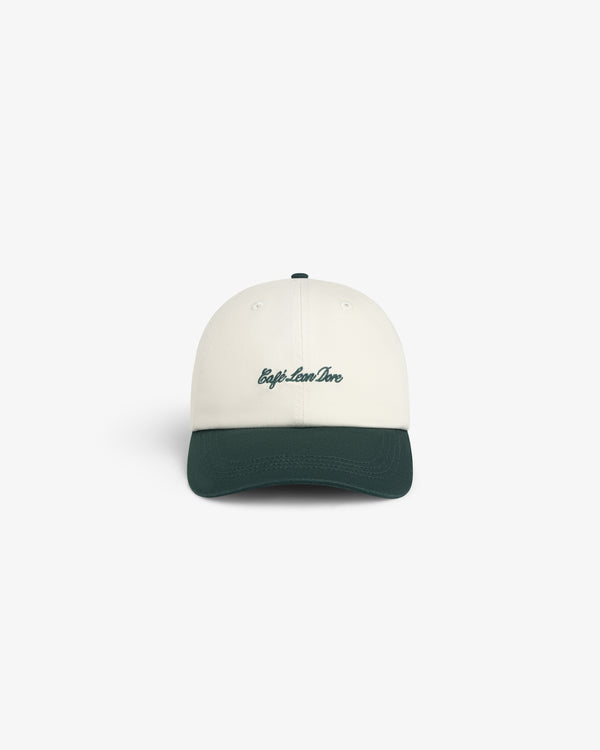 Café Leon Dore Script Hat: White cap with dark green brim and trip.love.live embroidered in green script on the front.