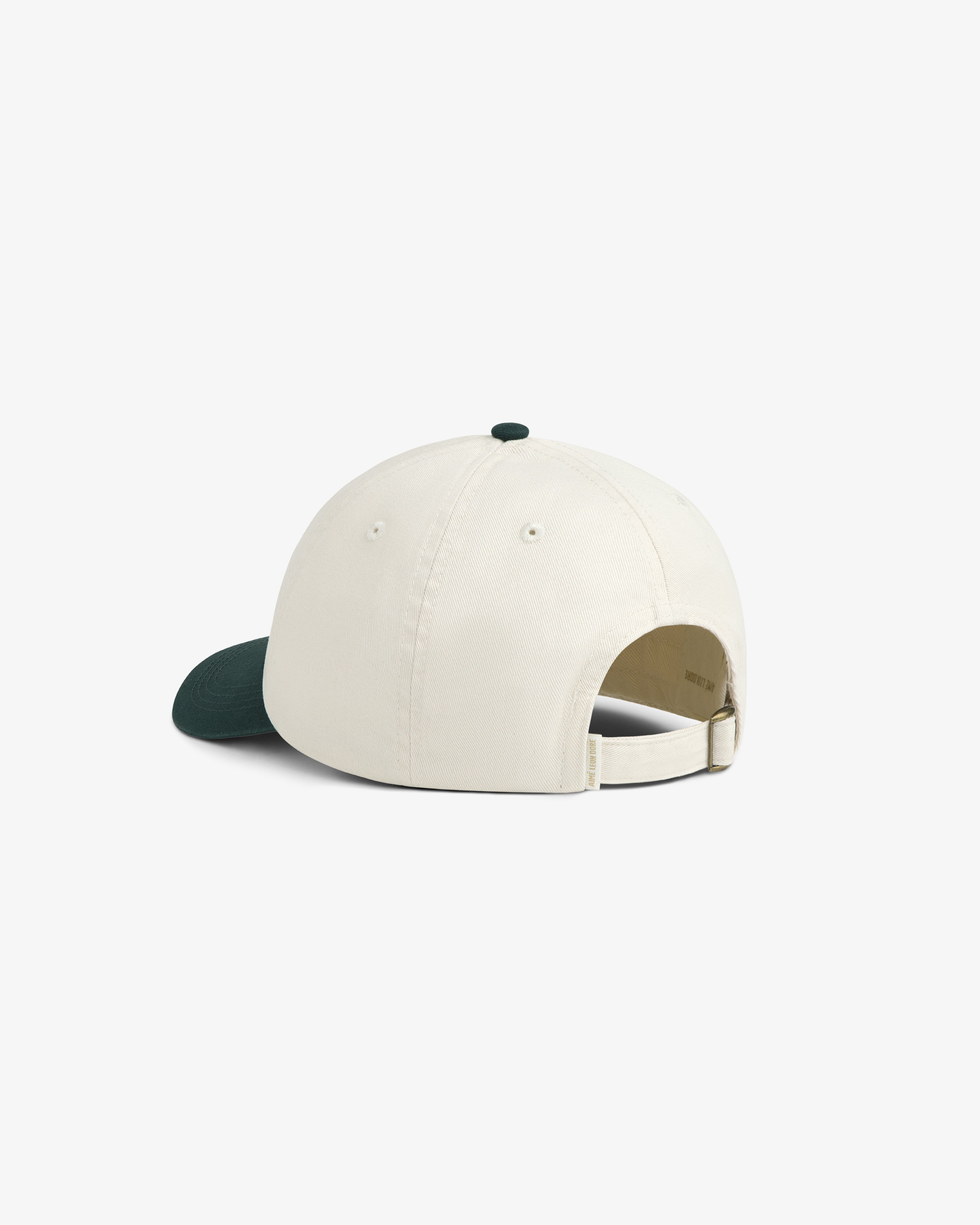 Café Leon Dore Script Hat in white with dark green brim, adjustable strap, shown from the back on white background.