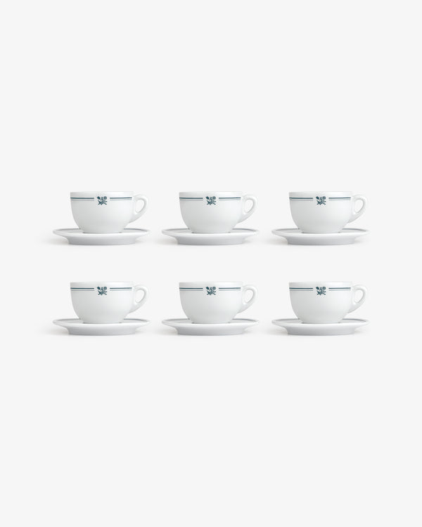 Set of 6 Café Leon Dore cappuccino cups with saucers, white with blue pattern, arranged in two rows on white background.