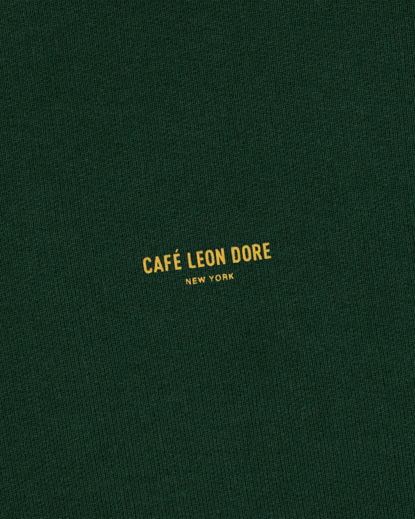 Dark green Café Leon Dore Crewneck Sweatshirt with centered yellow “CAFÉ LEON DORE NEW YORK” text.