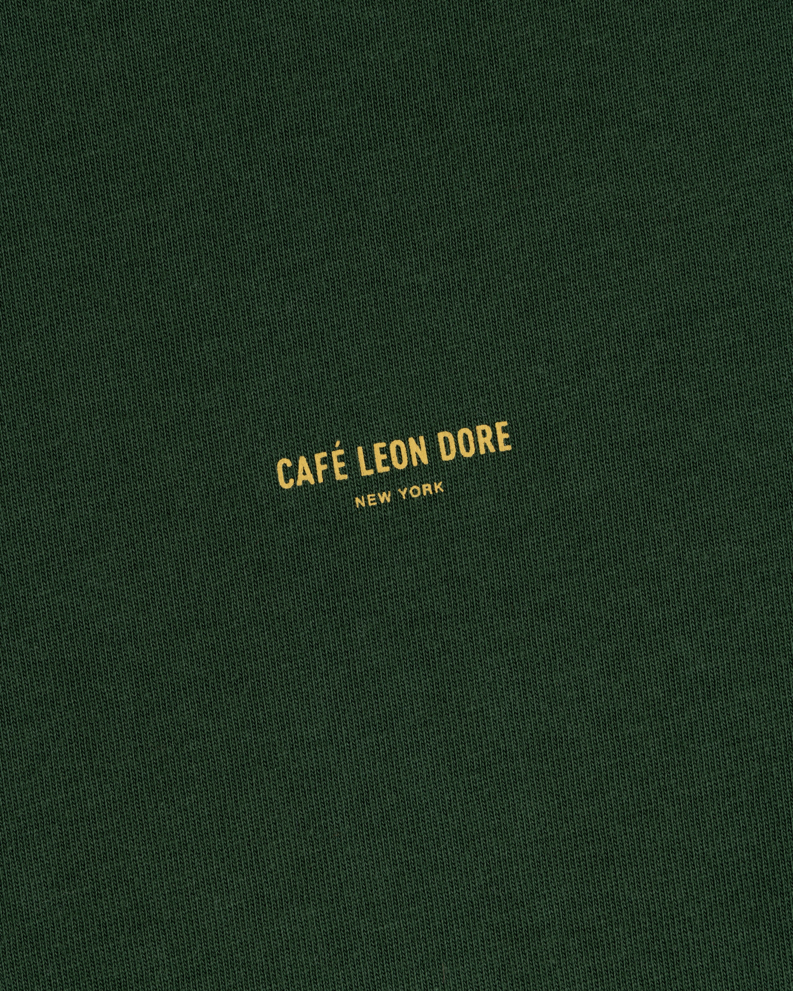 Dark green Café Leon Dore Logo Tee with small yellow “CAFÉ LEON DORE NEW YORK” printed at the center.