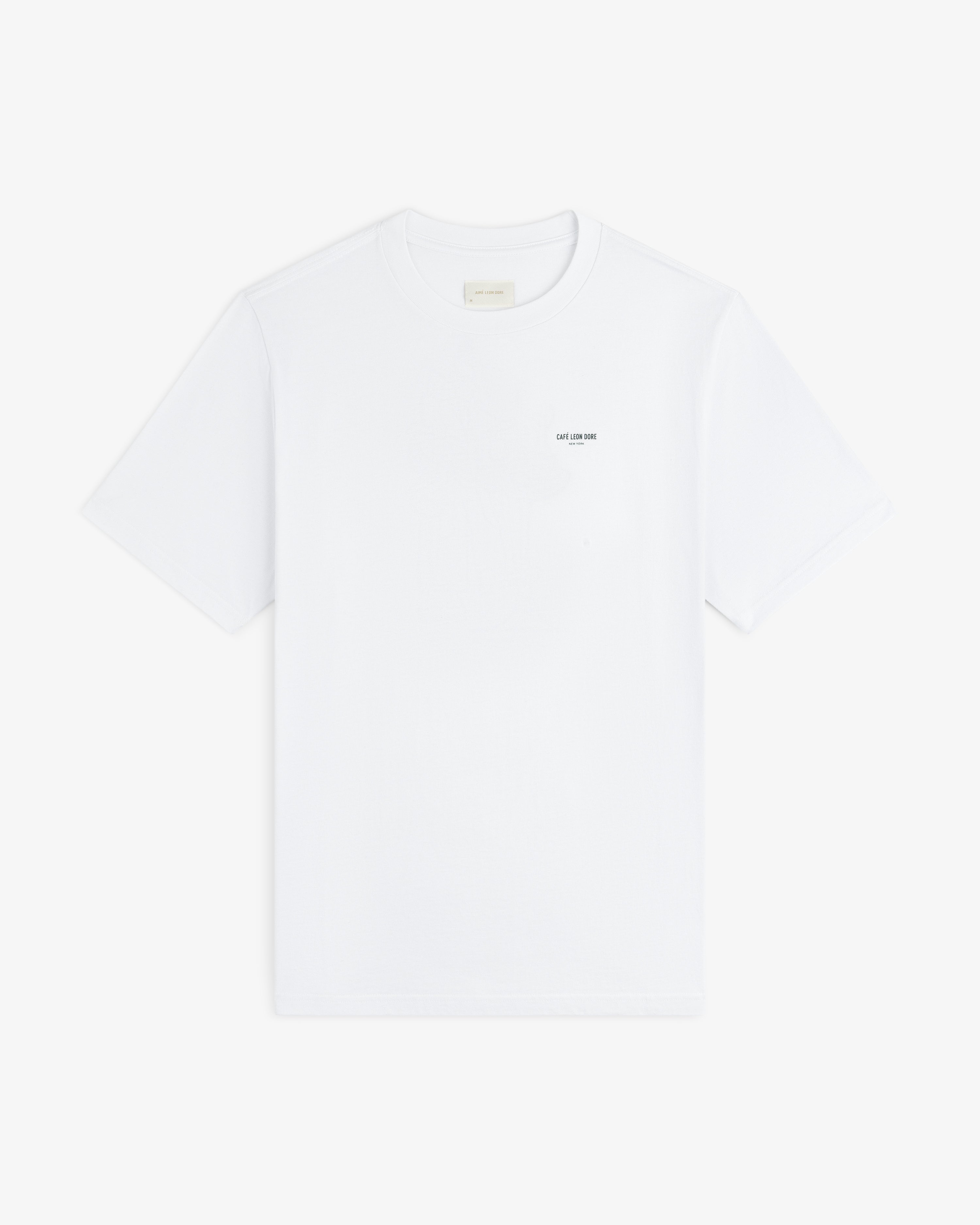 Café Leon Dore Caricature Tee: white short-sleeve shirt with small black text on left chest, on white background.