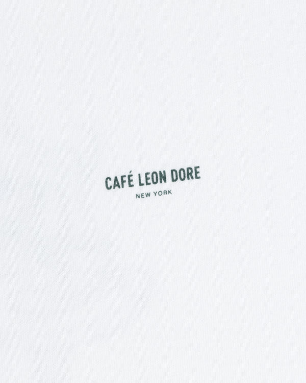 White Café Leon Dore Caricature Tee with “CAFÉ LEON DORE NEW YORK” in small black letters near the center.