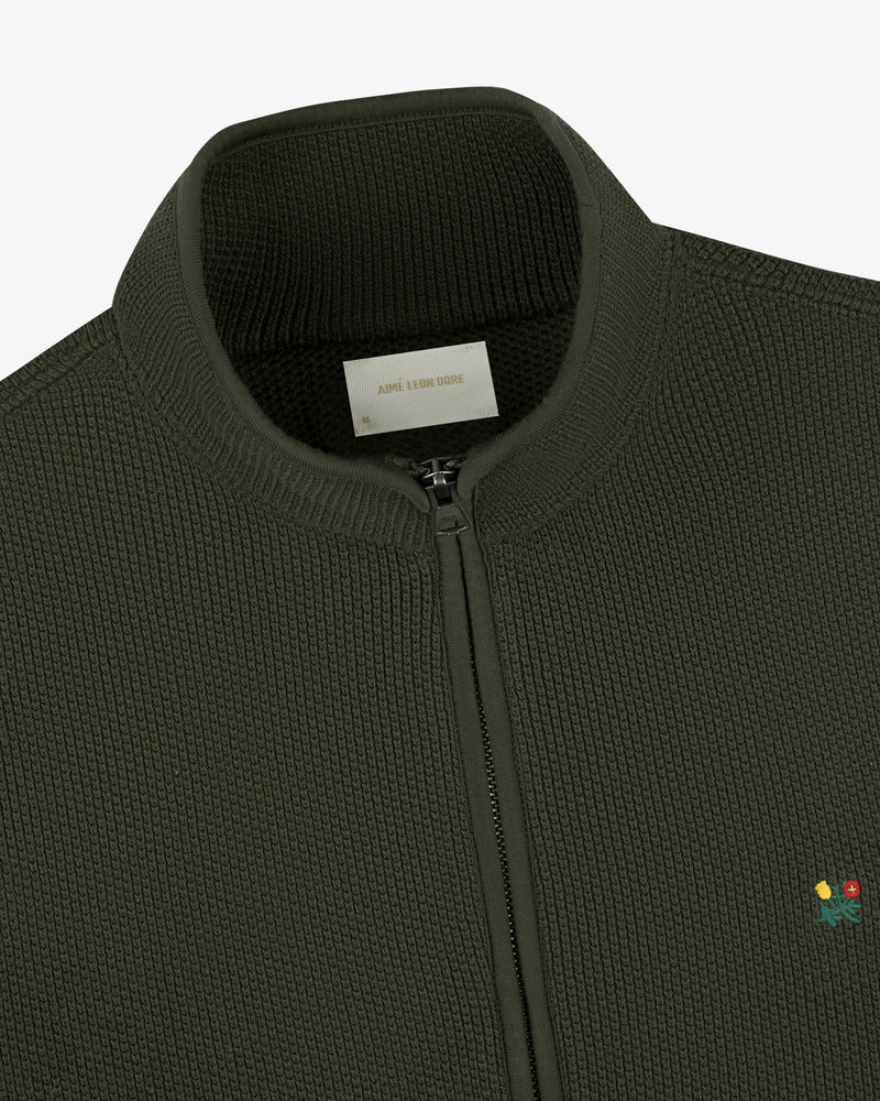Dark green Crest Piqué Half-Zip Pullover with ribbed collar and small embroidered chest flower.