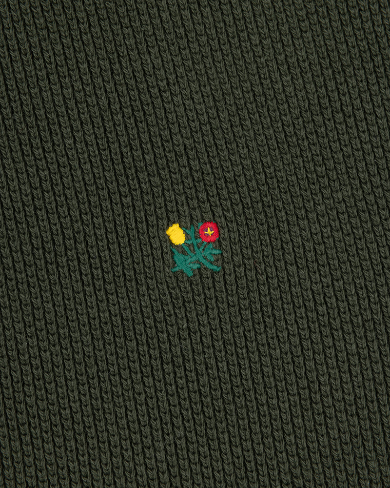 Dark green Crest Piqué Half-Zip Pullover with ribbed fabric, embroidered yellow-red flowers, and green leaves center.