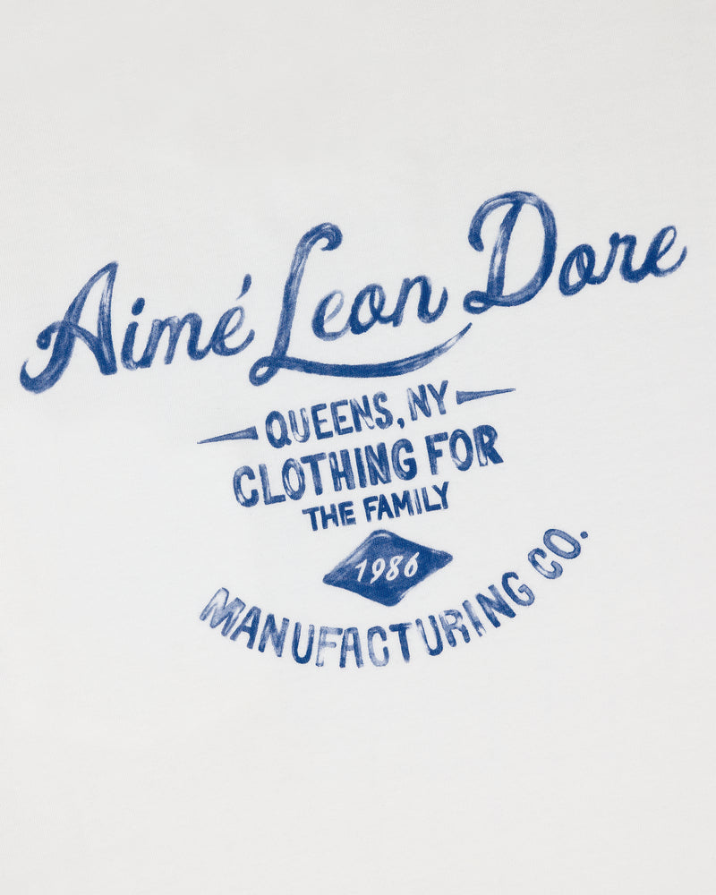 Blue script on white fabric reads General Store Pocket Tee, Aimé Leon Dore, Queens, NY, Clothing for the Family, 1986.