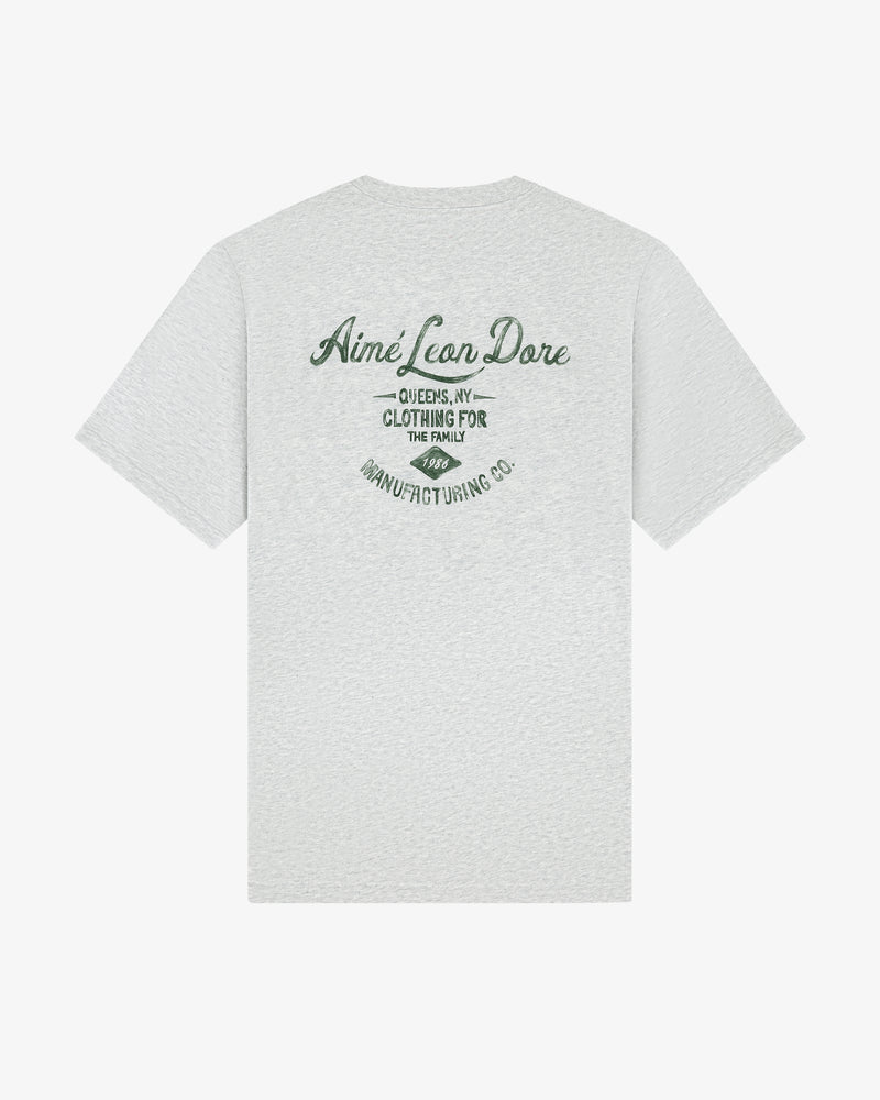 Back view of the General Store Pocket Tee in light gray with green text: “Aimé Leon Dore, Queens, NY, Clothing for the Family.”.