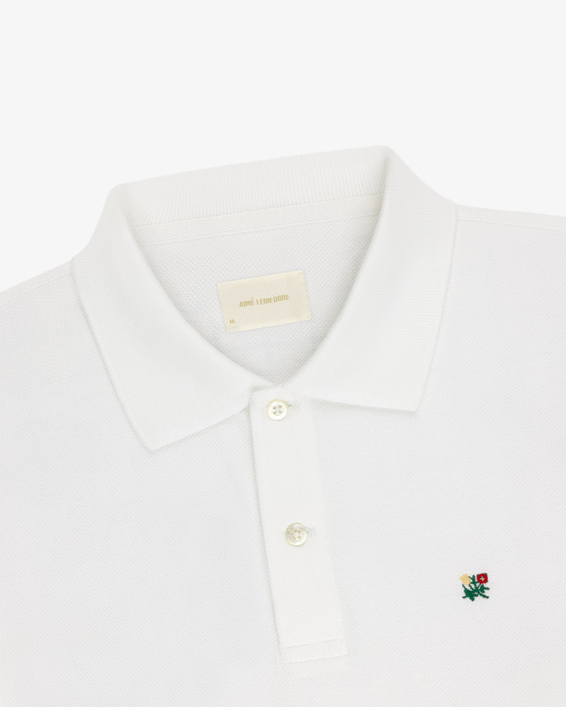 Long-Sleeve Crest Piqué Polo with collar, two buttons, and small green and red crest logo on the chest.