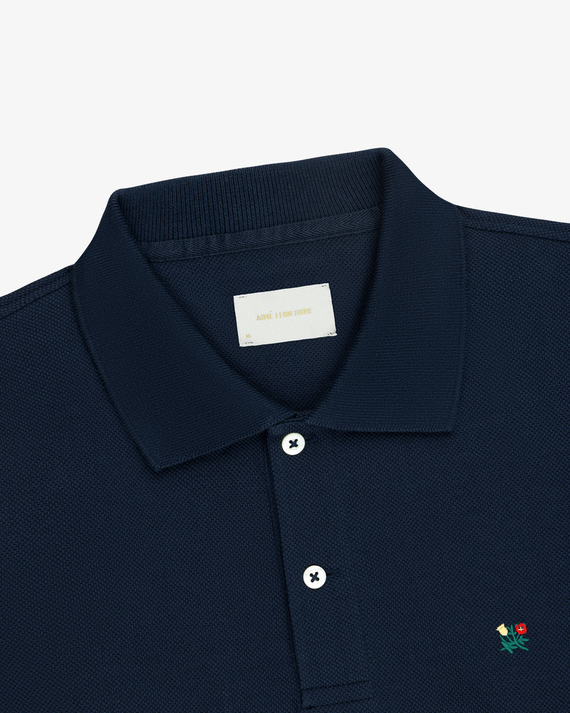Long-Sleeve Crest Piqué Polo in navy blue with white buttons and a small red rose and green leaf on the chest.