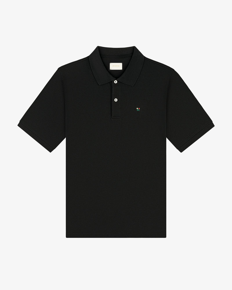 Crest Piqué Polo: black short-sleeve, collared shirt with small chest logo, shown on white background.
