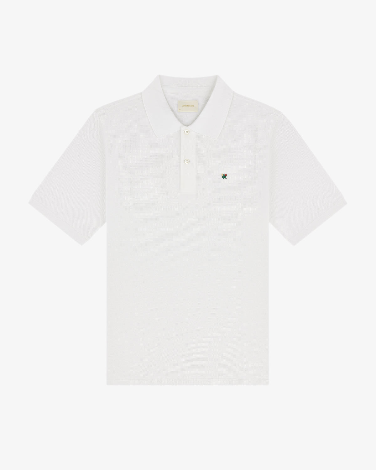 Crest Piqué Polo: white short-sleeve shirt with collar, button placket, and small logo on left chest.