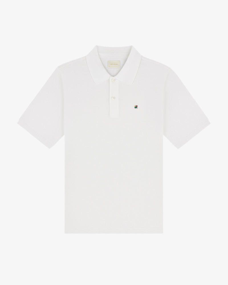Crest Piqué Polo: white short-sleeve shirt with collar, button placket, and small logo on left chest.