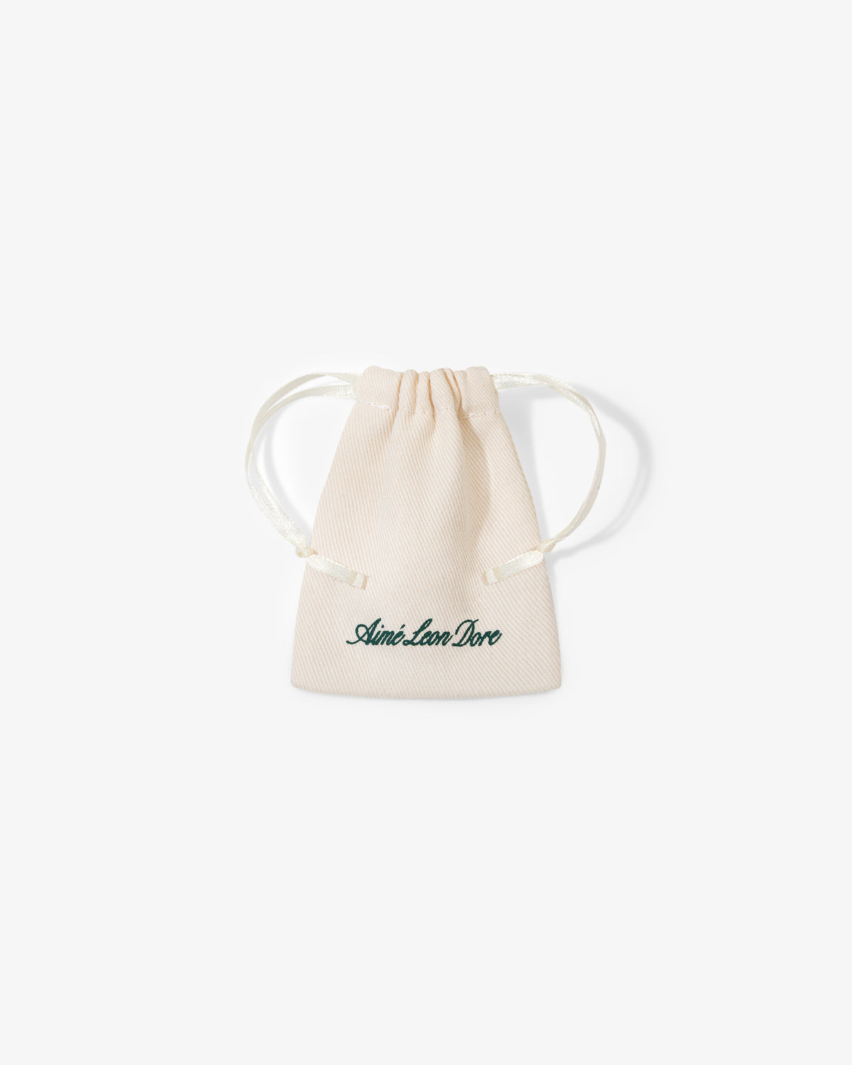 A small beige drawstring pouch with "Queens Crest Penny" printed in green script on the front.