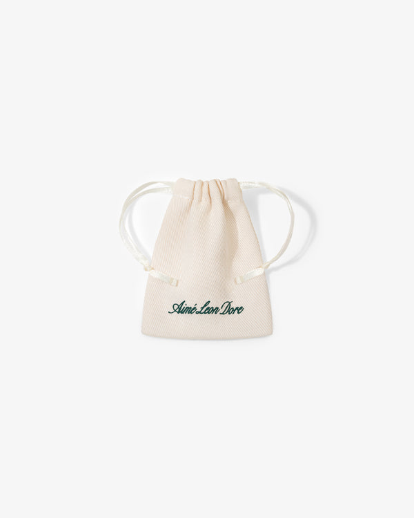 A small beige drawstring pouch with "Queens Crest Penny" printed in green script on the front.