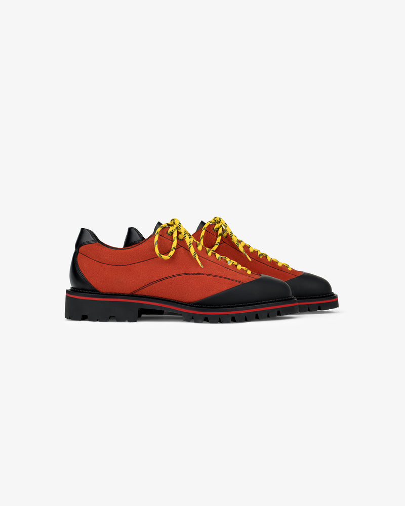 Suede Derby Hiker: orange and black low-tops with chunky soles, yellow-black laces on white background.