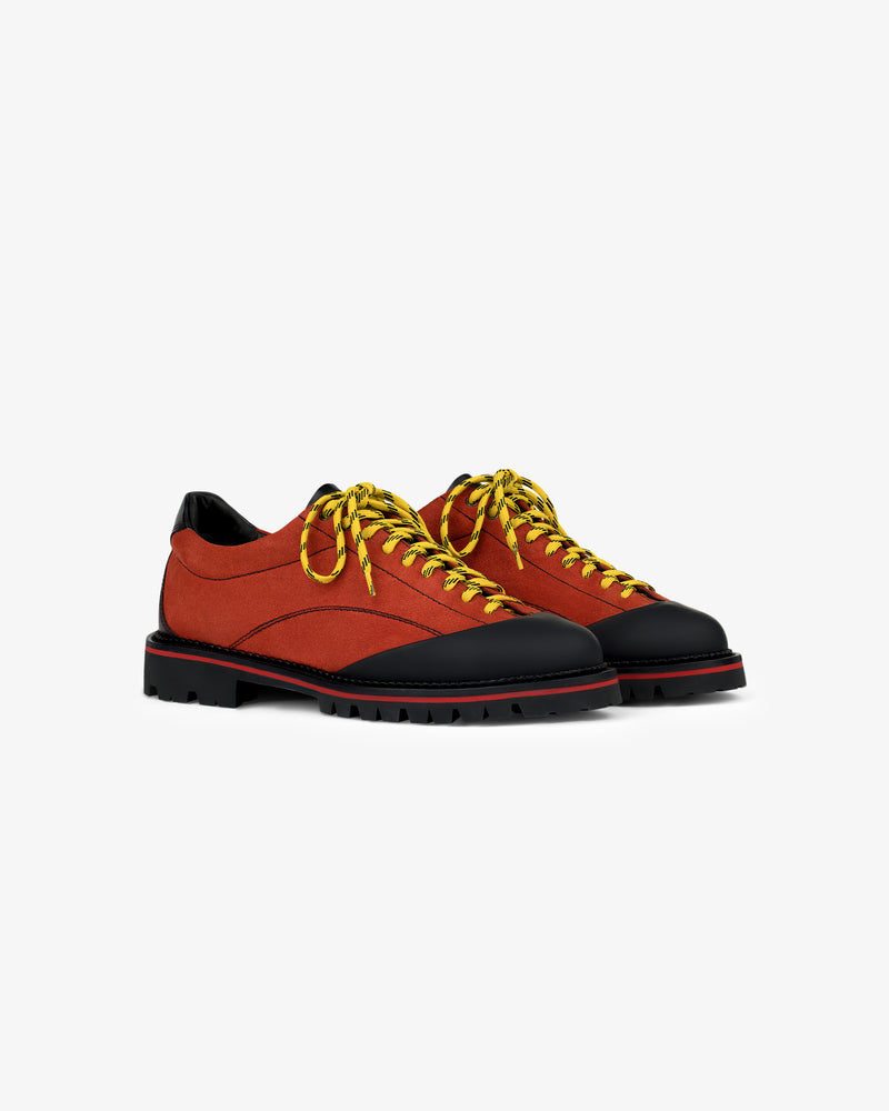 Suede Derby Hiker: red/black low-tops with yellow laces, rugged soles, and a sleek, modern design on white background.