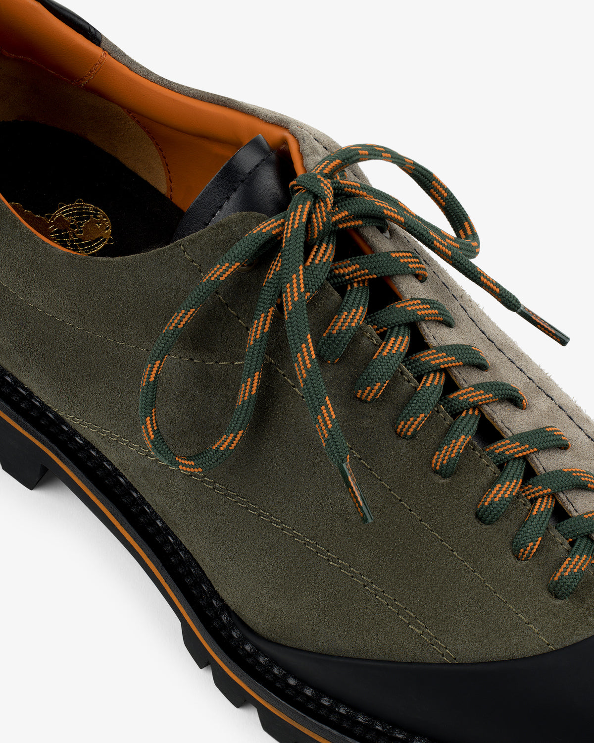 Close-up of the Suede Derby Hiker in olive green with orange & green laces, black sole, and orange inner lining.