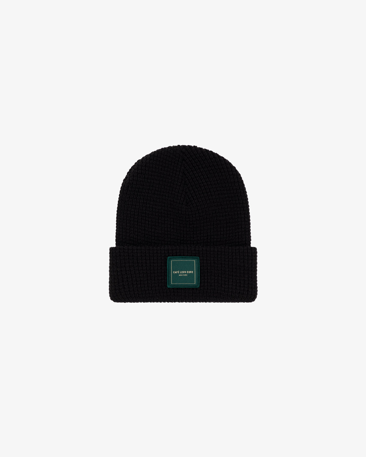 Café Leon Dore Beanie in black knit with a folded brim and green patch, shown on a white background.