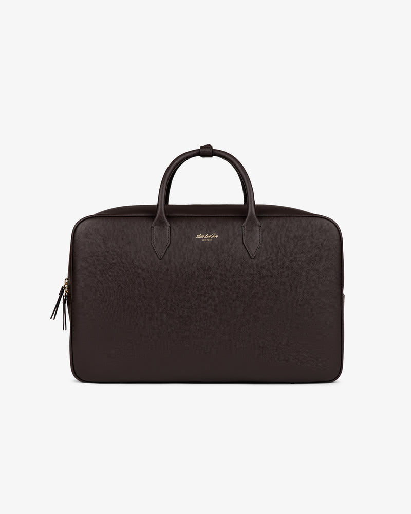 The Full Grain Leather Briefcase Duffle is dark brown with two handles and a zipper, shown on a white background.
