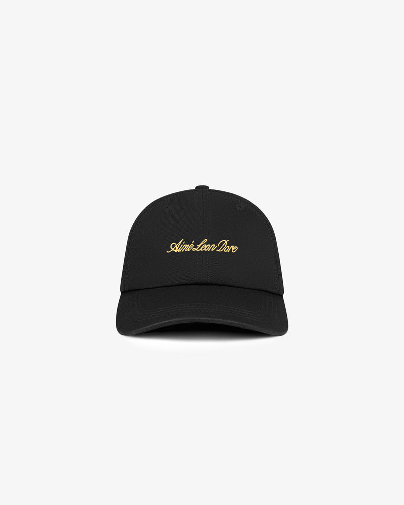Washed Script Hat: black baseball cap with gold Aimé Leon Dore script logo, shown on a white background.
