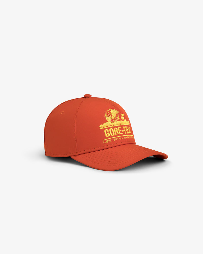 The GORE-TEX Unisphere Hat is an orange baseball cap with a yellow logo graphic, shown on a white background.