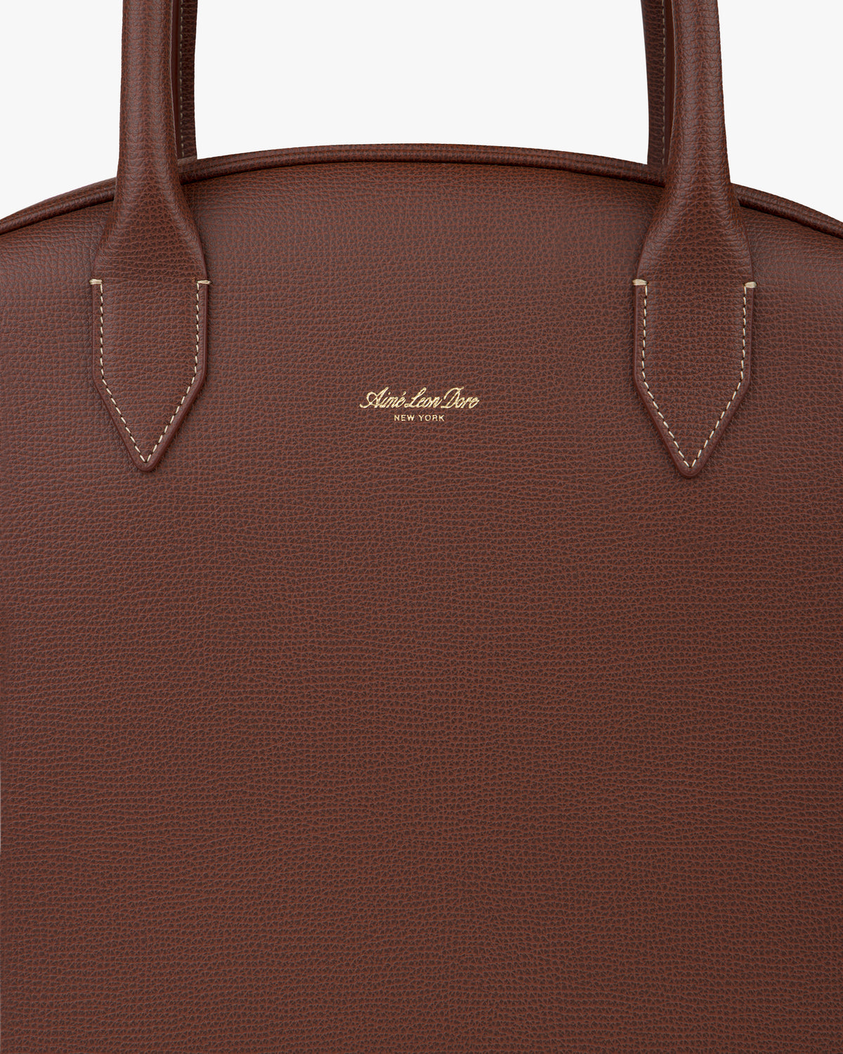 Close-up of a brown Full Grain Leather Crescent Shoulder Bag with two handles and gold Alexander Drew New York logo.