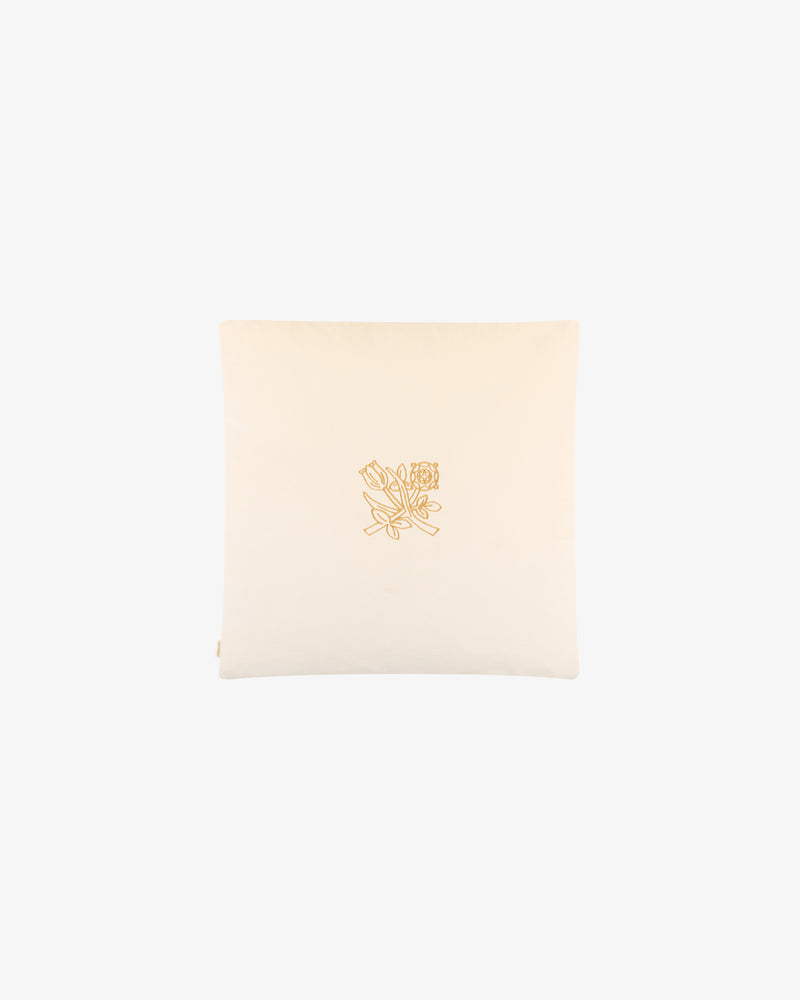 Queens Crest Throw Pillow: cream-colored with central gold floral embroidery, shown on a plain background.