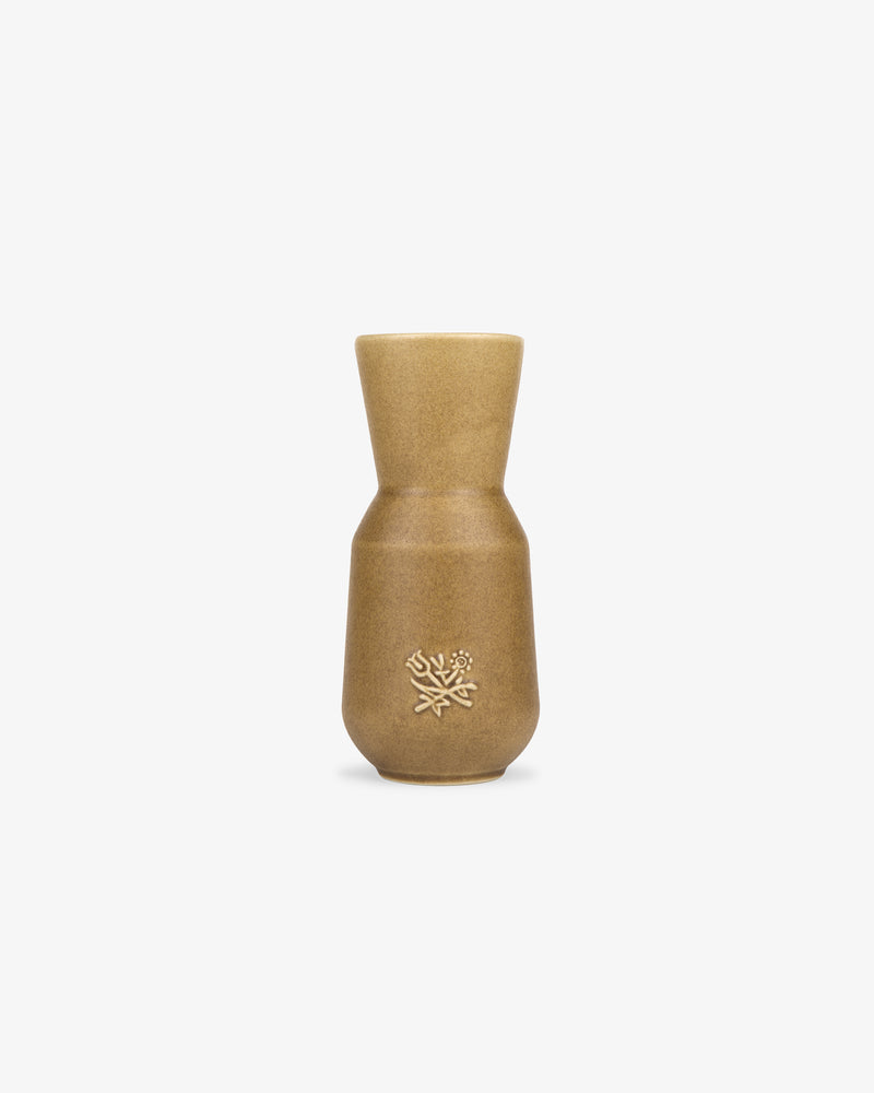 Queens Crest Artisanal Vase: tan ceramic with a narrow neck and embossed floral design, shown on a white background.