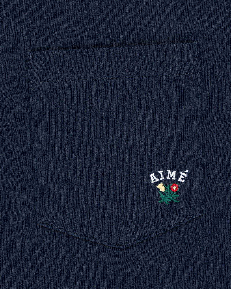 Crest Pocket Tee in navy blue with AIMÉ text and small yellow and red embroidered flowers below the pocket.