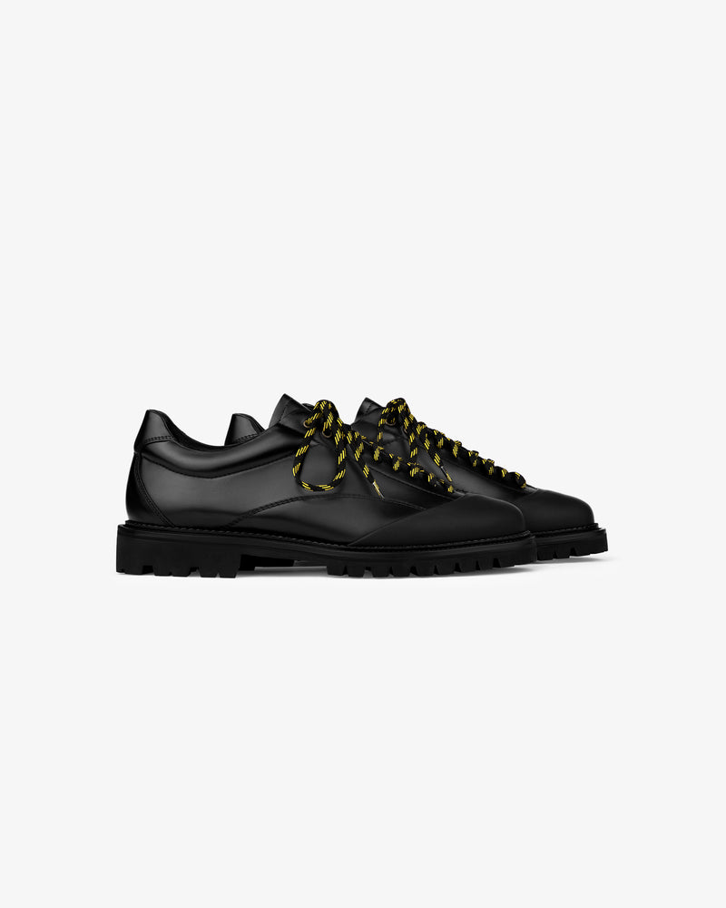 Leather Derby Hiker: black leather shoes with chunky soles and black-yellow striped laces on white background.