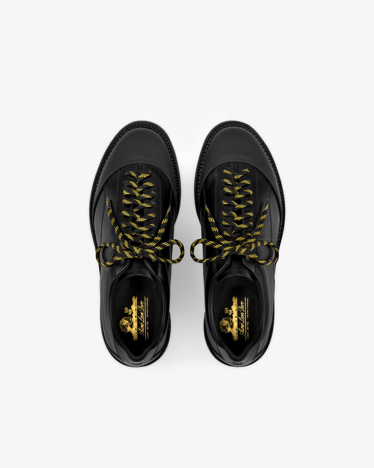 A top view of the Leather Derby Hiker shoes in black with yellow and black laces on a white background.